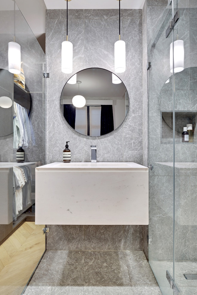 Exemple d'une petite salle d'eau tendance avec une douche à l'italienne, un carrelage gris, du carrelage en marbre, un mur gris, un sol en marbre, un lavabo suspendu, un plan de toilette en marbre, un sol gris, une cabine de douche à porte battante et un plan de toilette blanc.