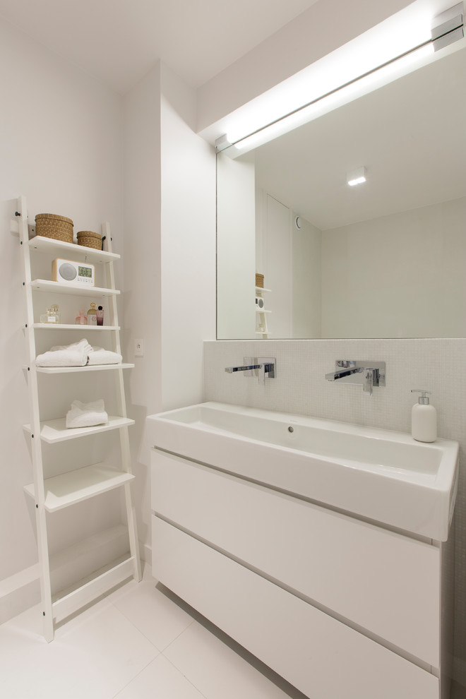 Diseño de cuarto de baño principal actual de tamaño medio con armarios con rebordes decorativos, puertas de armario blancas, paredes blancas, lavabo de seno grande y suelo blanco