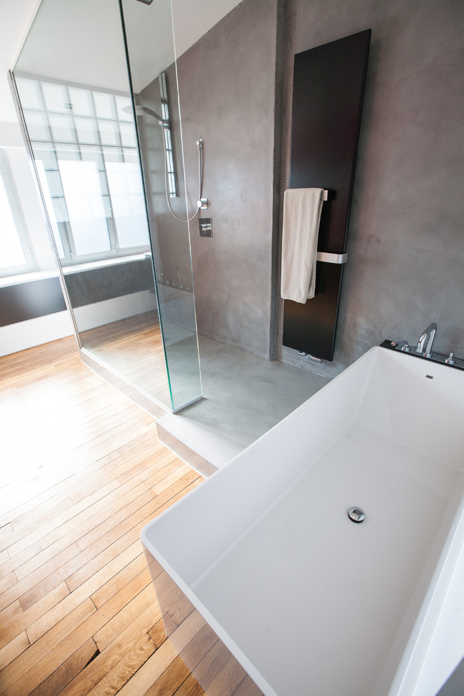 Cette image montre une salle de bain design avec une baignoire posée, une douche à l'italienne et un mur orange.