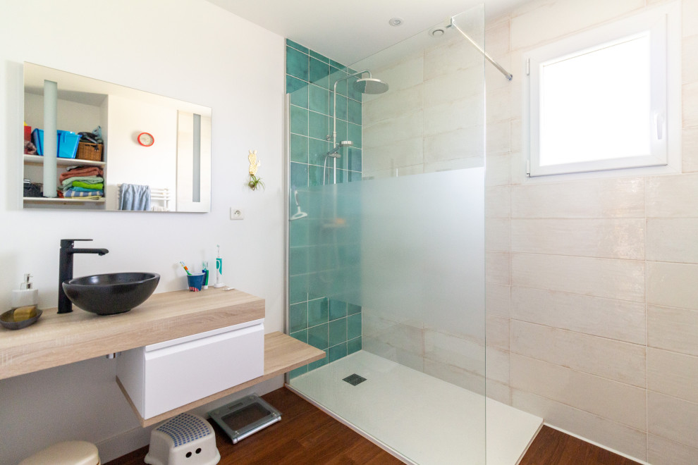 Immagine di una piccola stanza da bagno con doccia moderna con doccia a filo pavimento, piastrelle verdi, pareti bianche, pavimento in bambù, lavabo a consolle e un lavabo