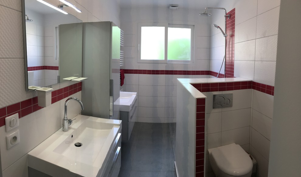 Cette image montre une salle de bain principale traditionnelle de taille moyenne avec des portes de placard grises, une douche à l'italienne, WC suspendus, un carrelage blanc, un mur blanc, un sol en carrelage de céramique, un plan vasque, un plan de toilette en surface solide et un sol gris.