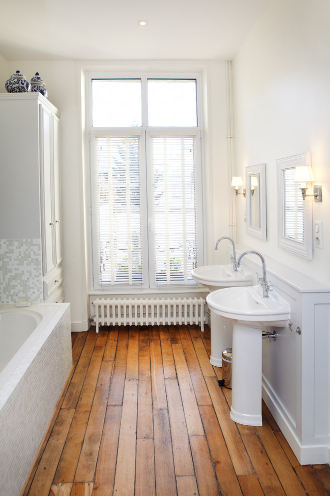 Inspiration för mellanstora klassiska en-suite badrum, med ett piedestal handfat, mosaik, vita väggar, mellanmörkt trägolv, vita skåp, ett platsbyggt badkar, beige kakel och grå kakel