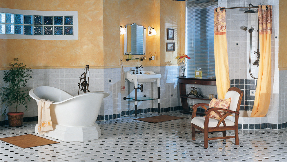 Klassisk inredning av ett badrum, med ett fristående badkar, en öppen dusch, grå kakel, svart kakel, flerfärgade väggar, ett konsol handfat, flerfärgat golv och dusch med duschdraperi