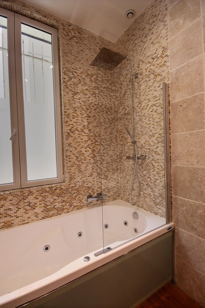 Ispirazione per una stanza da bagno padronale industriale di medie dimensioni con vasca idromassaggio, piastrelle beige, piastrelle in travertino, pareti beige e pavimento in legno massello medio