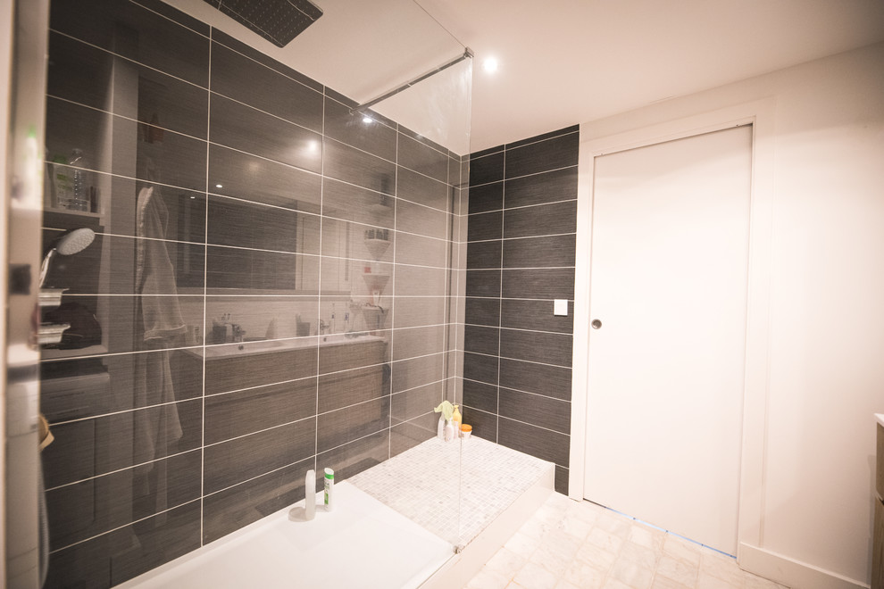 Exempel på ett mellanstort industriellt en-suite badrum, med en kantlös dusch, svart kakel, keramikplattor, vita väggar, travertin golv, ett väggmonterat handfat och vitt golv