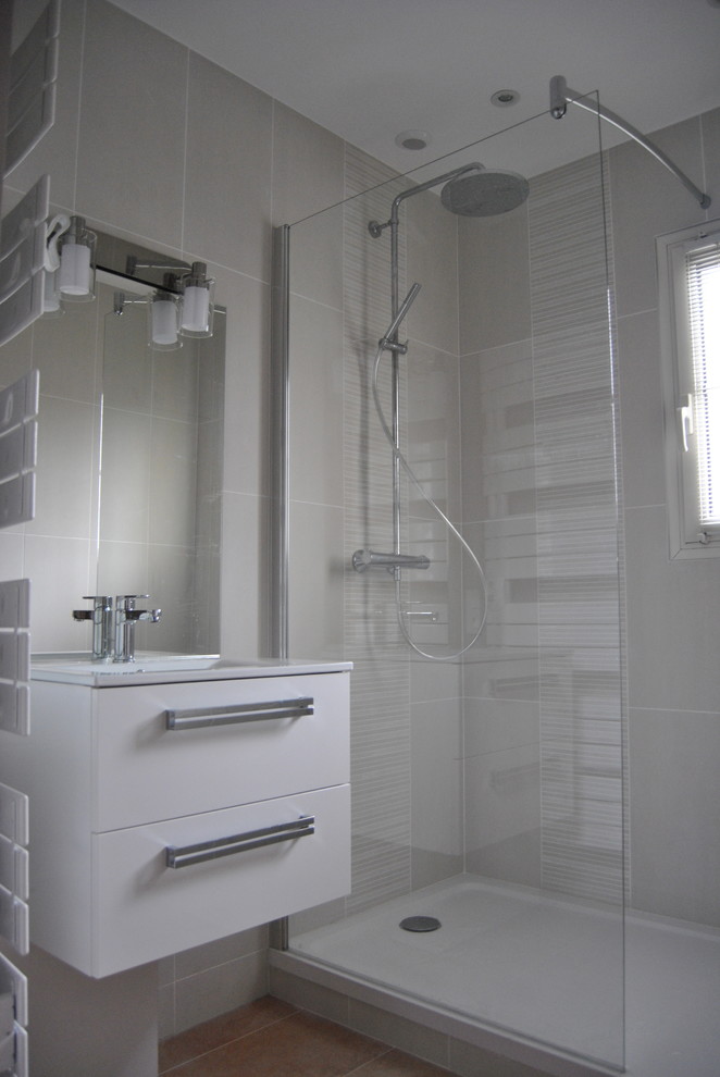 На фото: маленькая ванная комната в стиле модернизм с белыми фасадами, душем без бортиков, терракотовой плиткой, серыми стенами, полом из терракотовой плитки, душевой кабиной, подвесной раковиной и серой плиткой для на участке и в саду