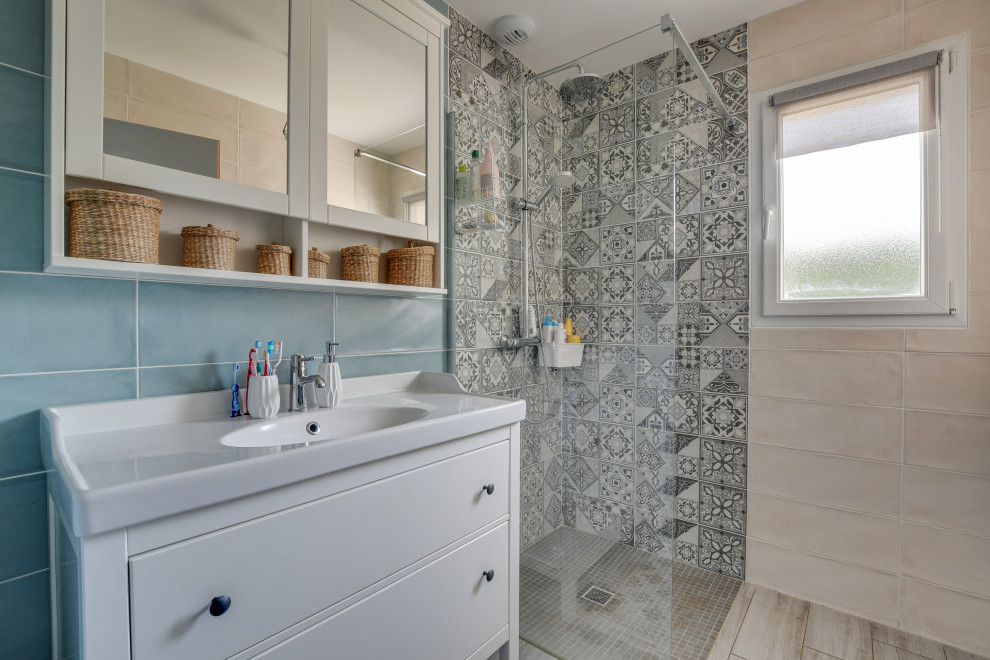 Idee per una piccola stanza da bagno con doccia stile marino con doccia a filo pavimento, piastrelle beige, pareti blu, lavabo a consolle e pavimento grigio