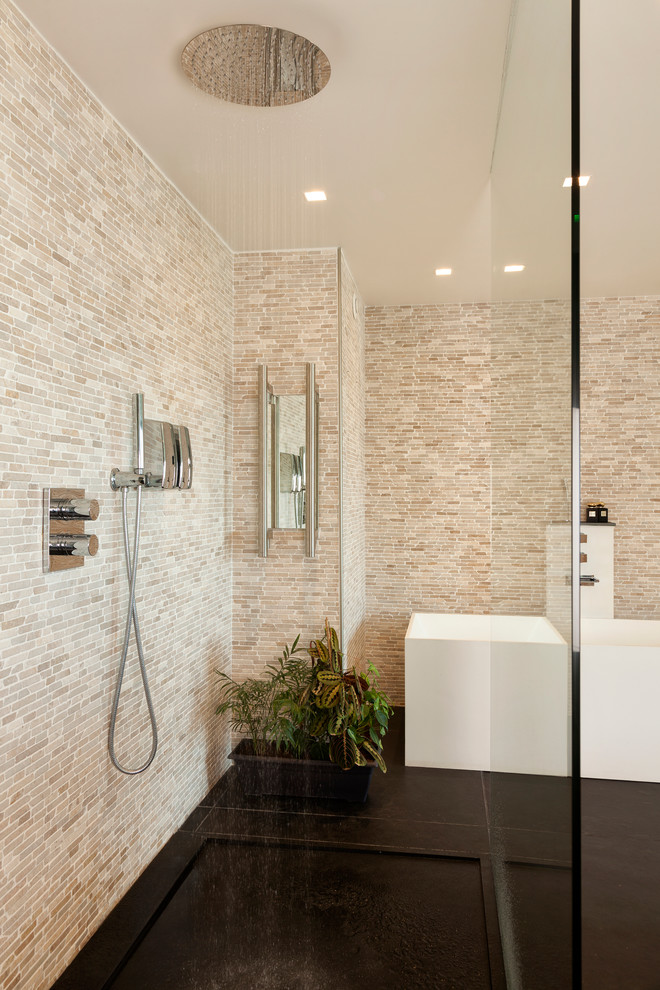 This is an example of a large contemporary ensuite bathroom in Paris with flat-panel cabinets, medium wood cabinets, a corner bath, a walk-in shower, beige tiles, beige walls, porcelain flooring, a trough sink, wooden worktops, black floors, an open shower and brown worktops.