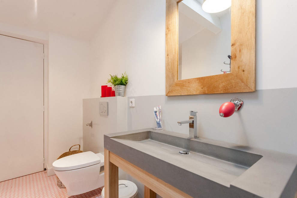 Bild på ett mellanstort funkis badrum, med en vägghängd toalettstol, vita väggar, ett konsol handfat och bänkskiva i betong