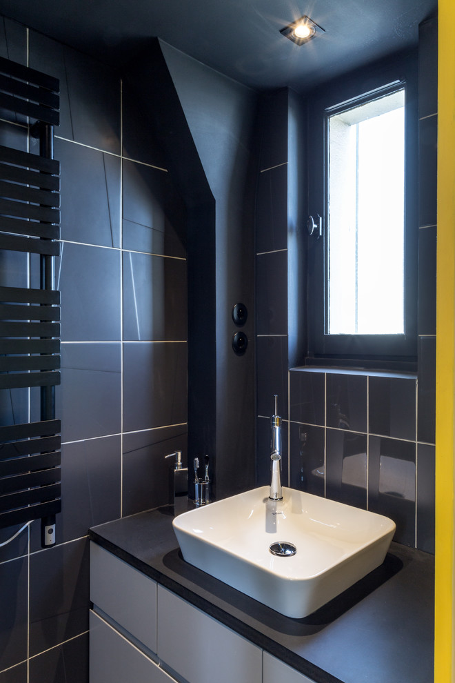 Modelo de cuarto de baño actual de tamaño medio con baldosas y/o azulejos negros, paredes negras y lavabo encastrado
