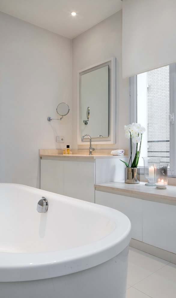 Esempio di una stanza da bagno padronale design di medie dimensioni con vasca freestanding, piastrelle bianche, pareti bianche e top bianco