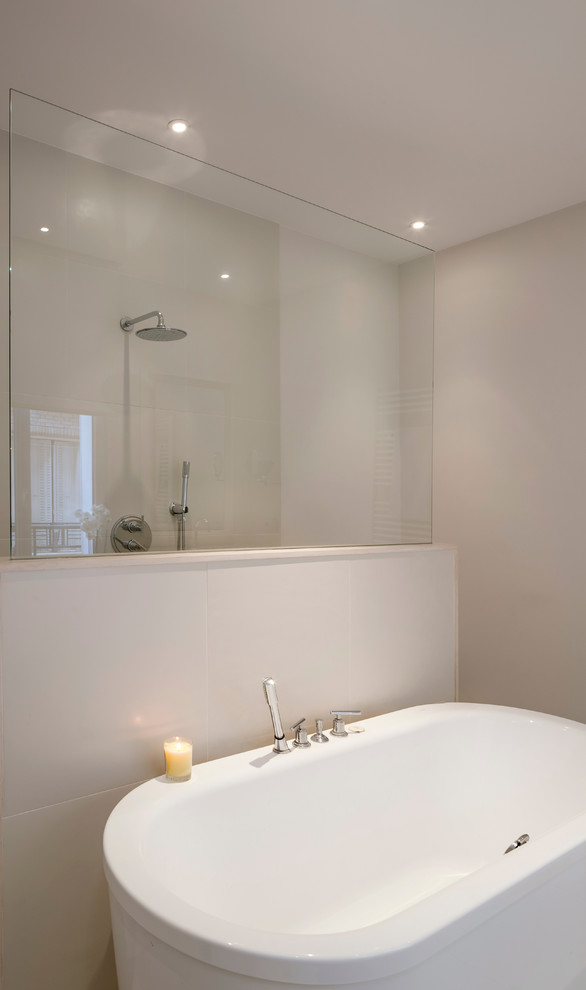 Cette photo montre une salle de bain principale tendance de taille moyenne avec une baignoire indépendante, un carrelage blanc, un mur blanc et un plan de toilette blanc.