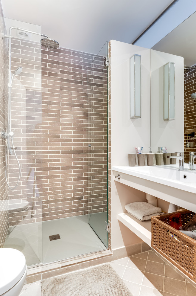 Inspiration för mellanstora moderna badrum med dusch, med en dusch i en alkov, en vägghängd toalettstol, beige kakel, vita väggar, klinkergolv i keramik, ett integrerad handfat och dusch med gångjärnsdörr