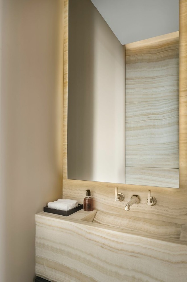 This is an example of a contemporary bathroom in Paris with an integrated sink, beige walls, stone slabs and beige tiles.