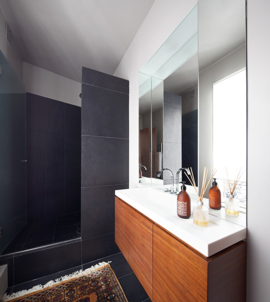 Cette image montre une petite salle de bain design en bois brun avec un carrelage gris, des carreaux de céramique, un mur blanc, un sol en carrelage de céramique et un lavabo intégré.