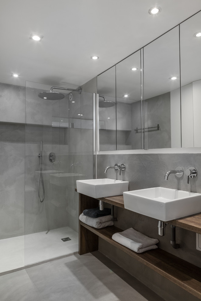 Idéer för ett modernt brun badrum med dusch, med en kantlös dusch, ett fristående handfat, träbänkskiva, öppna hyllor och skåp i mörkt trä