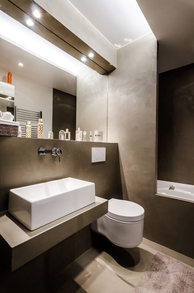 Ejemplo de cuarto de baño principal contemporáneo con lavabo sobreencimera, sanitario de pared y microcemento
