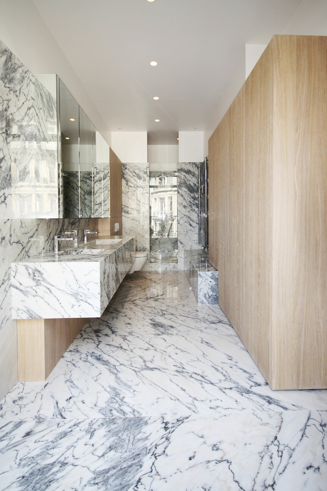 На фото: большая ванная комната в современном стиле с душем в нише, инсталляцией, плиткой из листового камня, душевой кабиной, монолитной раковиной, мраморной столешницей, серой плиткой и белой плиткой