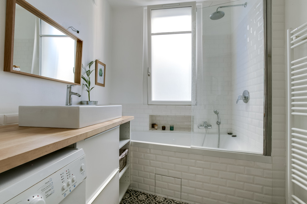 Cette photo montre une salle de bain principale scandinave de taille moyenne avec une baignoire encastrée, un mur blanc, carreaux de ciment au sol, un lavabo posé et un plan de toilette en bois.