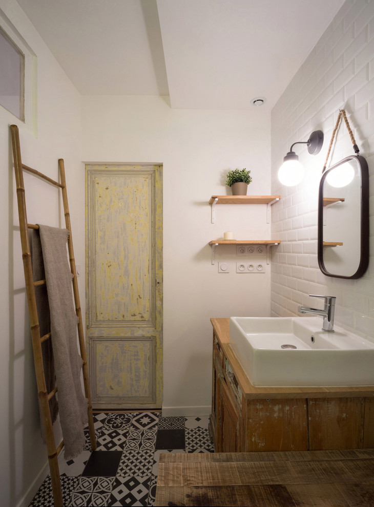 Eklektisk inredning av ett mellanstort en-suite badrum, med skåp i slitet trä, ett fristående badkar, svart och vit kakel, cementkakel, vita väggar, cementgolv och ett nedsänkt handfat