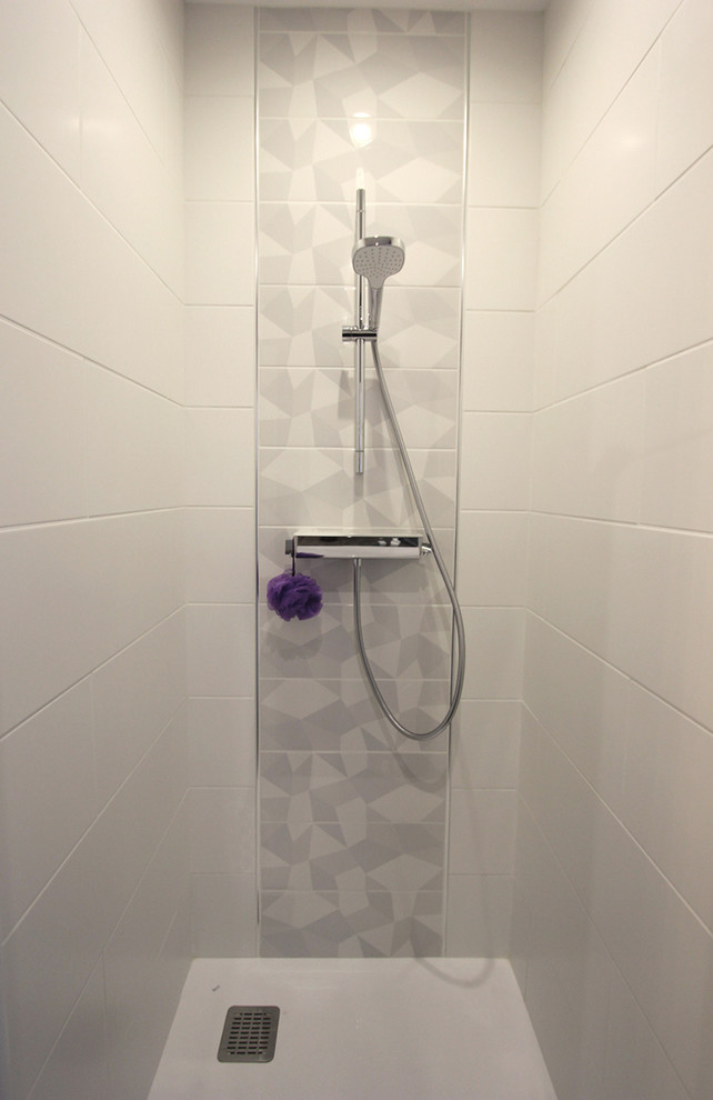 Inredning av ett modernt mellanstort vit vitt en-suite badrum, med släta luckor, vita skåp, ett undermonterat badkar, en öppen dusch, grå kakel, keramikplattor, vita väggar, laminatgolv, ett konsol handfat, bänkskiva i akrylsten, grått golv och dusch med gångjärnsdörr