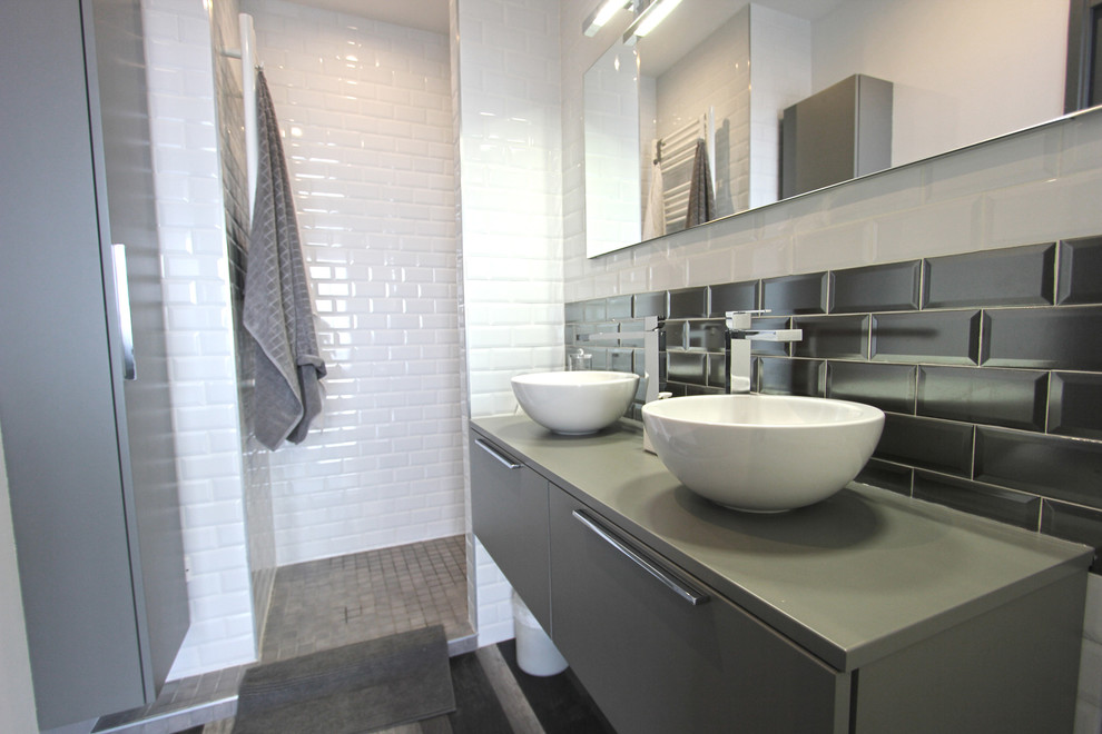 Inredning av ett modernt mellanstort grå grått badrum med dusch, med släta luckor, grå skåp, en kantlös dusch, vit kakel, tunnelbanekakel, vita väggar, laminatgolv, ett nedsänkt handfat, bänkskiva i akrylsten, grått golv och med dusch som är öppen