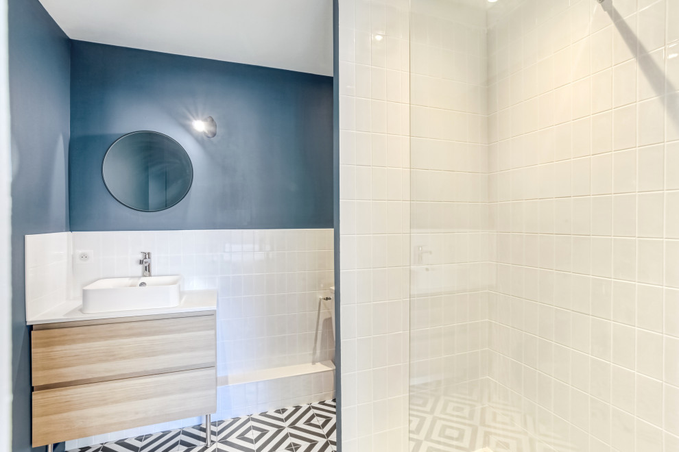 Idée de décoration pour une salle de bain minimaliste en bois clair avec une baignoire encastrée, un carrelage blanc, un mur vert, carreaux de ciment au sol, une vasque et meuble simple vasque.