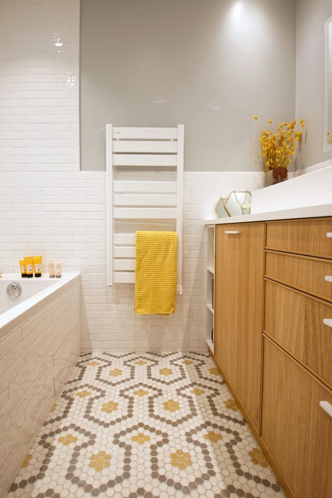 Пример оригинального дизайна: главная ванная комната среднего размера в скандинавском стиле с фасадами с декоративным кантом, светлыми деревянными фасадами, полновстраиваемой ванной, белой плиткой, удлиненной плиткой, синими стенами, полом из мозаичной плитки, столешницей из кварцита, желтым полом и белой столешницей