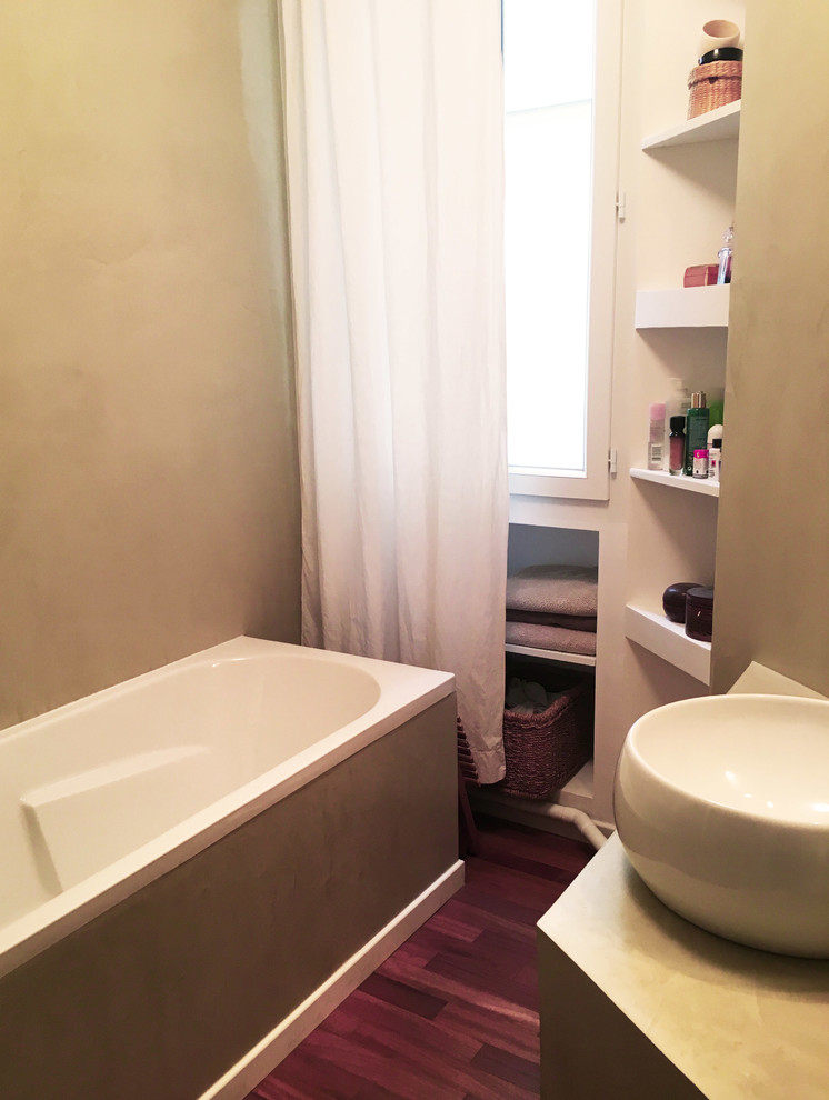Cette photo montre une salle de bain tendance de taille moyenne avec une baignoire encastrée, parquet foncé et un lavabo posé.