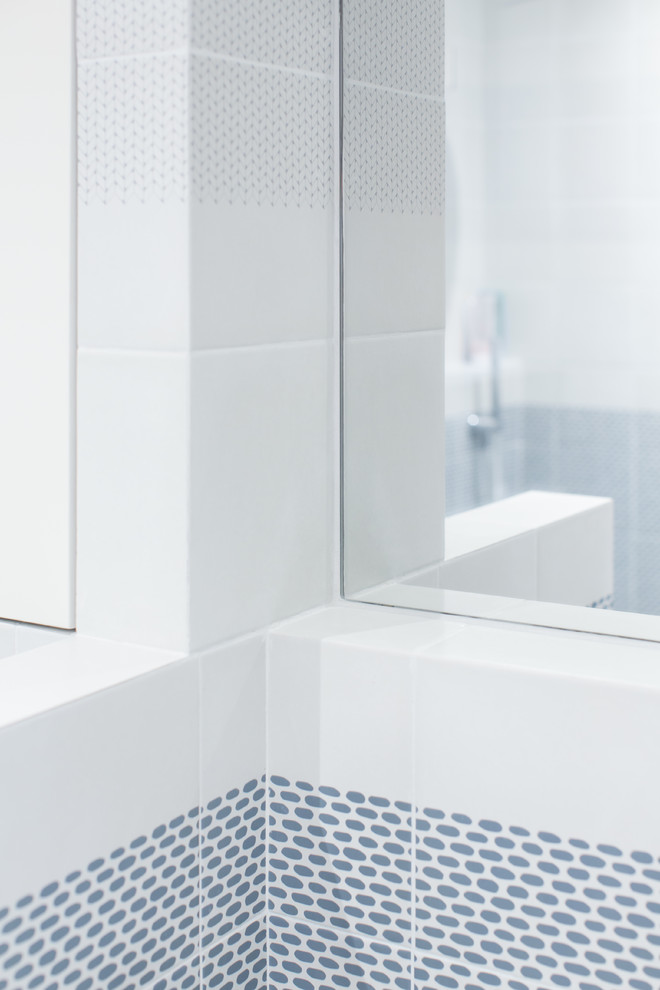 Diseño de cuarto de baño escandinavo pequeño con armarios abiertos, sanitario de pared, baldosas y/o azulejos azules, baldosas y/o azulejos grises, suelo de cemento, aseo y ducha, lavabo suspendido, suelo gris, puertas de armario blancas y paredes blancas