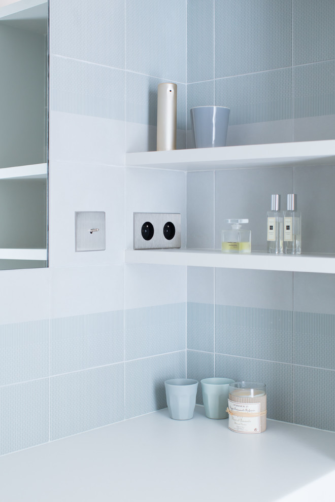 Modelo de cuarto de baño escandinavo pequeño con armarios abiertos, sanitario de pared, baldosas y/o azulejos verdes, suelo de cemento, aseo y ducha, lavabo suspendido y suelo gris