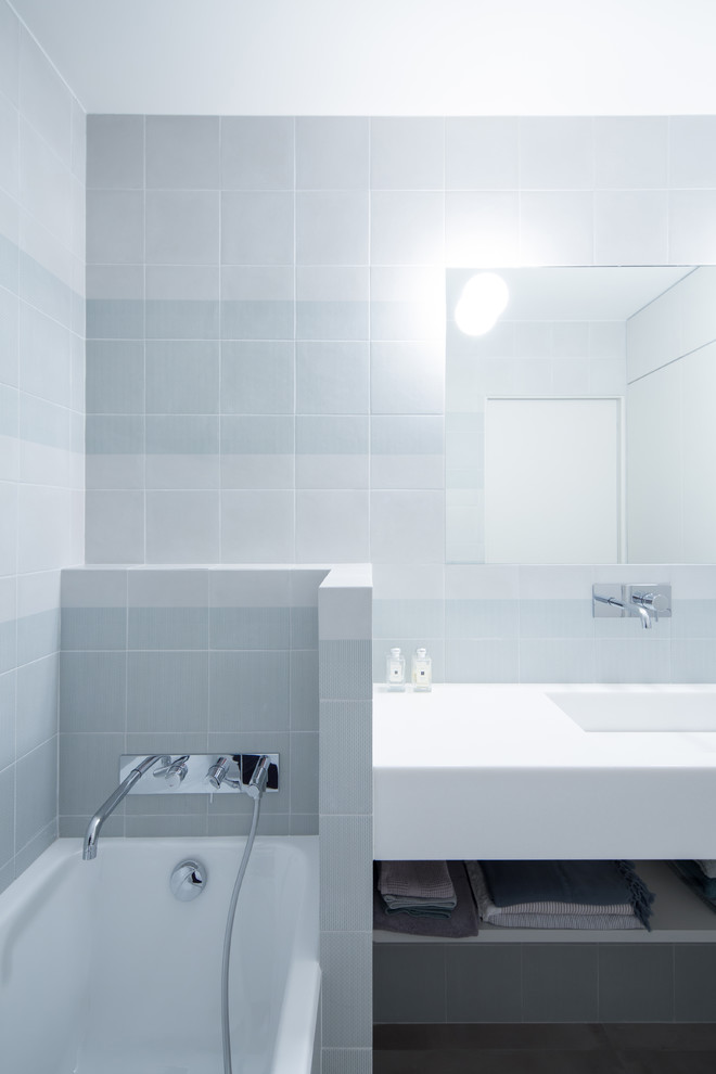 Diseño de cuarto de baño escandinavo pequeño con armarios abiertos, sanitario de pared, baldosas y/o azulejos verdes, suelo de cemento, aseo y ducha, lavabo suspendido y suelo gris