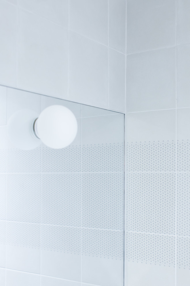 Kleines Nordisches Duschbad mit offenen Schränken, Wandtoilette, blauen Fliesen, grauen Fliesen, Betonboden, Wandwaschbecken, grauem Boden, weißen Schränken und weißer Wandfarbe in Paris