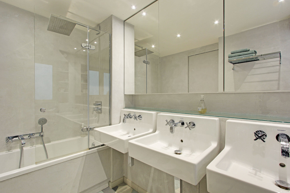 Imagen de cuarto de baño infantil actual de tamaño medio con bañera esquinera, combinación de ducha y bañera, paredes beige, lavabo suspendido y ducha abierta
