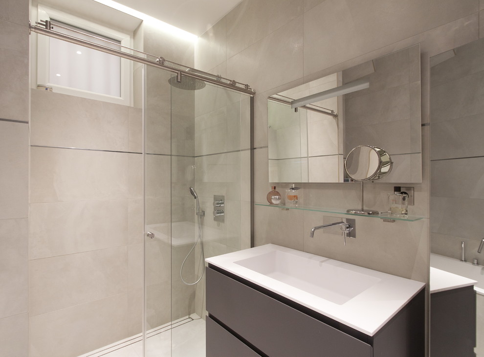 Inredning av ett modernt mellanstort en-suite badrum, med grå skåp, en kantlös dusch, en toalettstol med separat cisternkåpa, beige kakel, vita väggar och ett undermonterad handfat