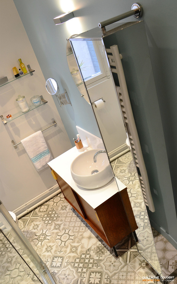 Photo of a small scandinavian ensuite bathroom in Paris with dark wood cabinets, a corner shower, cement tiles, blue walls and a built-in sink.