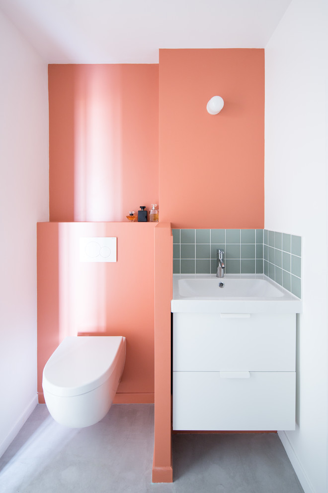 Foto di una piccola stanza da bagno padronale scandinava con ante bianche, WC sospeso, piastrelle bianche, piastrelle rosa, piastrelle a listelli, pareti bianche, pavimento in cemento, lavabo sottopiano e pavimento grigio