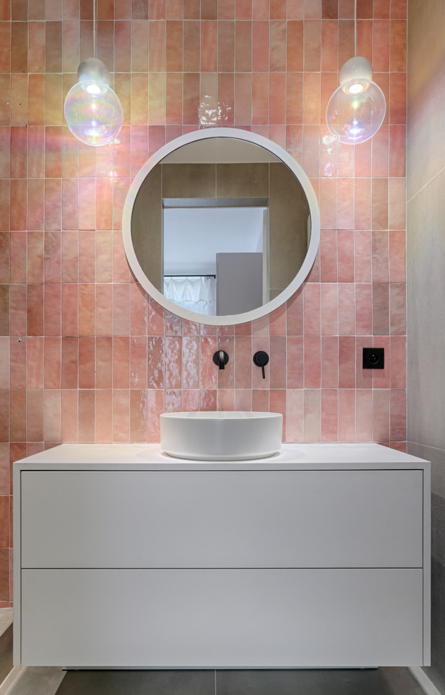 На фото: детская ванная комната в скандинавском стиле с плоскими фасадами, белыми фасадами, розовой плиткой, розовыми стенами, настольной раковиной, серым полом, белой столешницей и зеркалом с подсветкой с