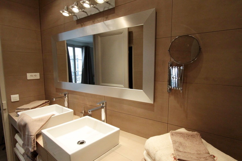 Cette photo montre une grande salle de bain principale chic avec un placard sans porte, un carrelage marron, des carreaux de béton, un mur marron et un lavabo posé.