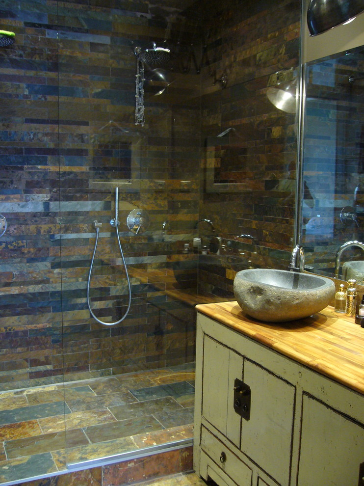 Idéer för mellanstora eklektiska en-suite badrum, med en kantlös dusch, brun kakel, stenhäll, bruna väggar, skiffergolv, ett nedsänkt handfat, träbänkskiva, luckor med lamellpanel, skåp i slitet trä och med dusch som är öppen