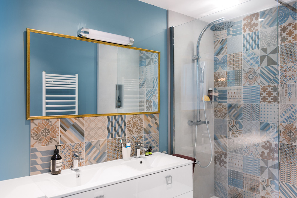 Ispirazione per una stanza da bagno con doccia contemporanea di medie dimensioni con lavabo integrato, doccia alcova, piastrelle multicolore e pareti blu