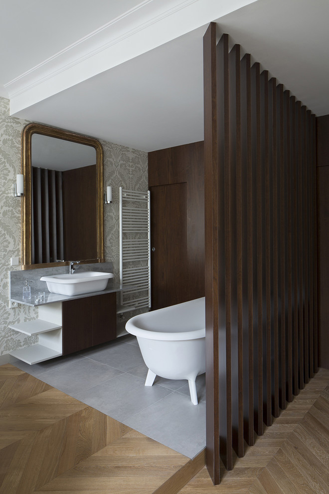 На фото: большая главная ванная комната в стиле неоклассика (современная классика) с ванной на ножках, разноцветными стенами, полом из линолеума и настольной раковиной с