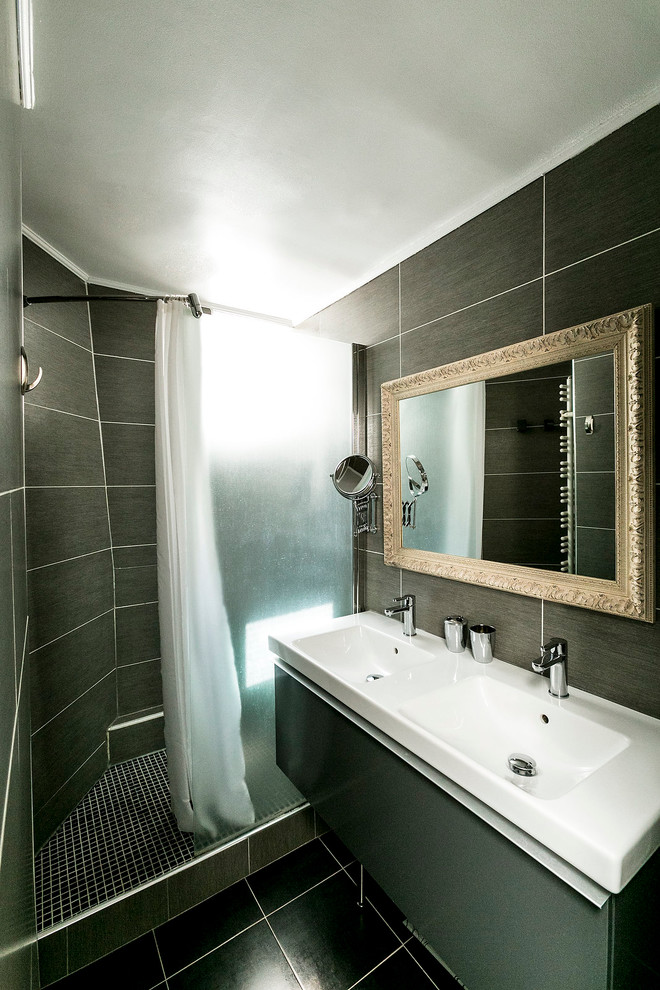 Immagine di una stanza da bagno con doccia design di medie dimensioni con ante grigie, doccia alcova, piastrelle nere, pavimento con piastrelle in ceramica e lavabo integrato