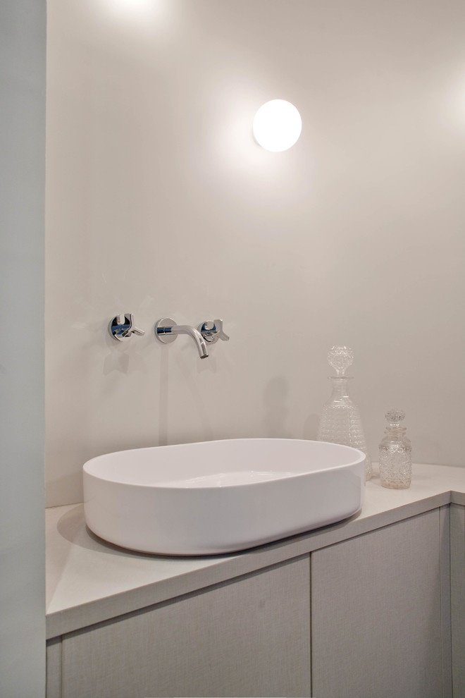 Cette photo montre une petite salle de bain principale et grise et blanche tendance avec un placard à porte plane, des portes de placard grises, un mur blanc, une vasque, meuble simple vasque et meuble-lavabo encastré.