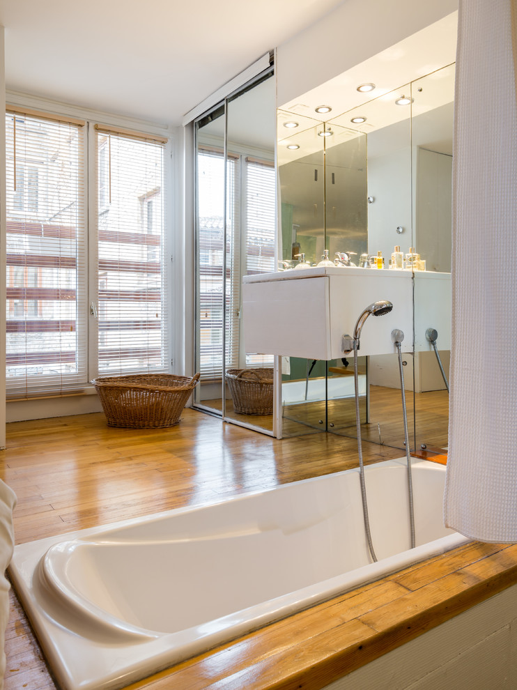 Nordisk inredning av ett litet en-suite badrum, med ett undermonterat badkar och mellanmörkt trägolv