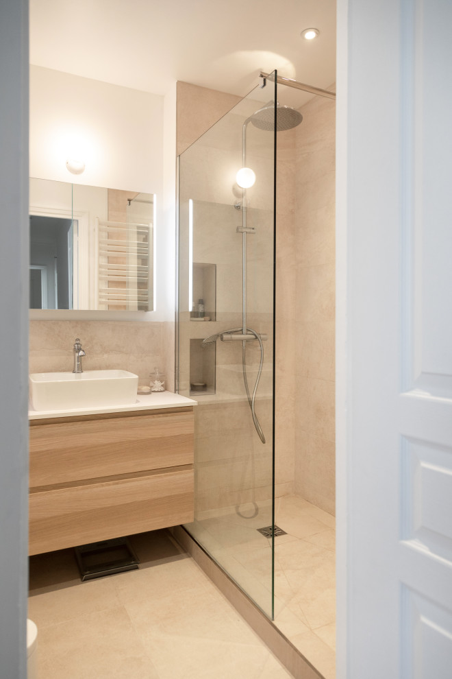 This is an example of a small modern ensuite bathroom in Other with flat-panel cabinets, light wood cabinets, a built-in shower, a two-piece toilet, beige tiles, travertine tiles, beige walls, travertine flooring, a vessel sink, solid surface worktops, beige floors, an open shower and white worktops.