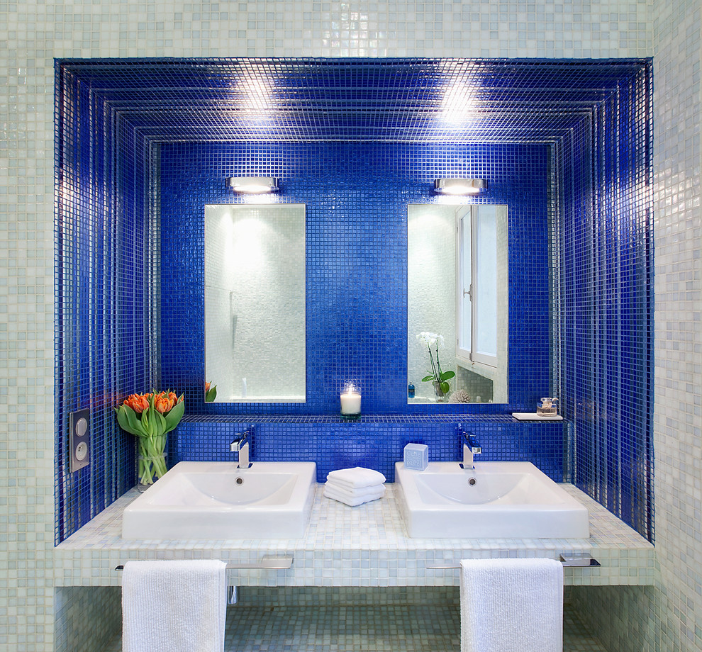 Bild på ett mellanstort funkis en-suite badrum, med kaklad bänkskiva, blå kakel, mosaik, ett platsbyggt badkar, blå väggar och ett nedsänkt handfat