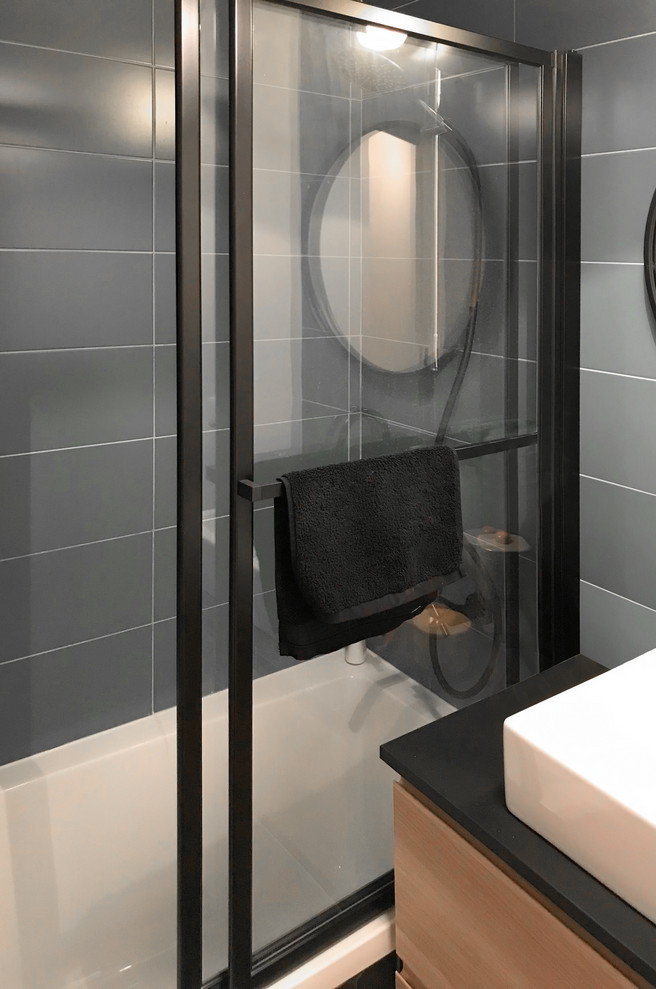 Esempio di una piccola stanza da bagno padronale design con vasca sottopiano, piastrelle blu, piastrelle in ceramica, pavimento con piastrelle in ceramica, lavabo a bacinella, top in laminato, pavimento nero e top nero