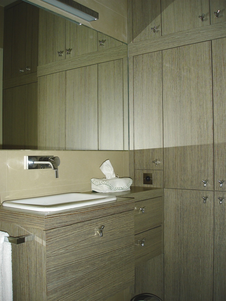 Cette image montre une salle de bain design en bois clair avec un placard à porte affleurante, un carrelage beige, un mur beige, un sol en carrelage de céramique, un lavabo encastré, un plan de toilette en bois et un sol beige.