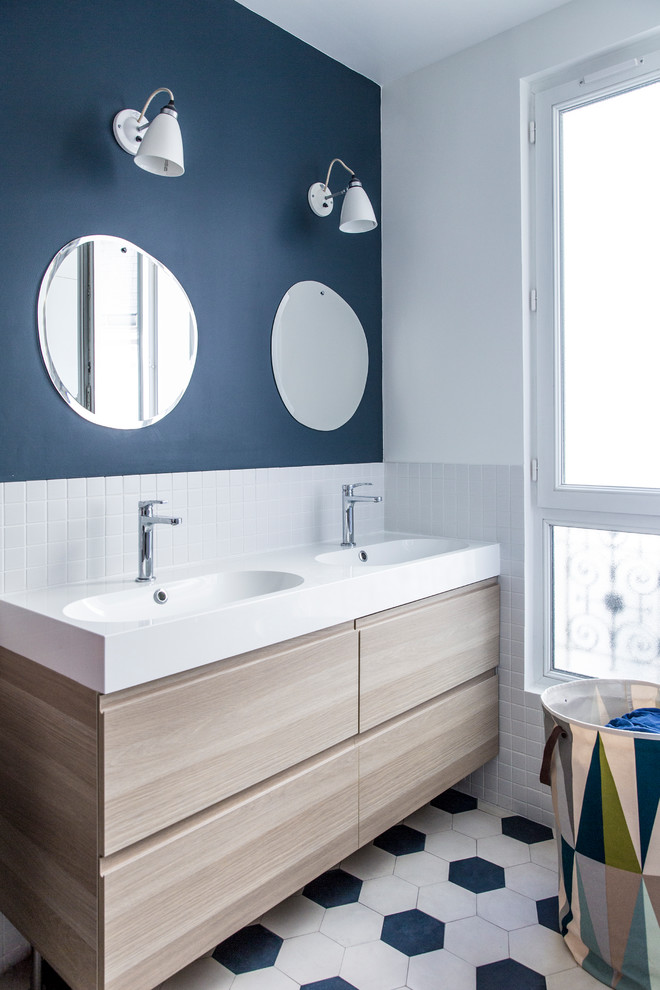 Idées déco pour une salle de bain contemporaine en bois clair avec un placard à porte plane, un carrelage blanc, mosaïque, un mur bleu, un plan vasque, un sol blanc et un plan de toilette blanc.